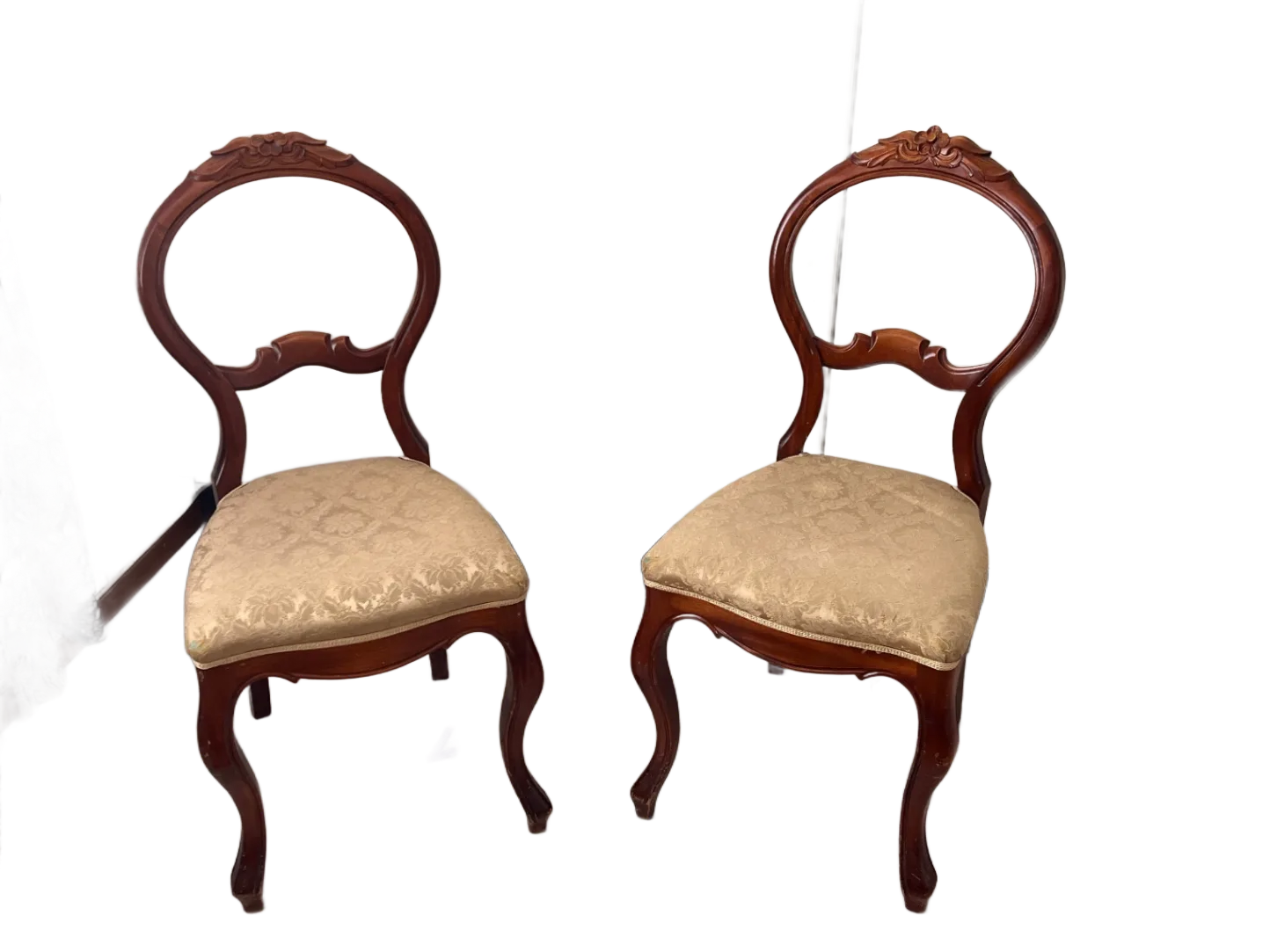 Ett par ballongryggstolar i rokokostil, troligen från sent 1800-tal eller tidigt 1900-tal, med snidade detaljer och stoppade sitsar i damastmönster.